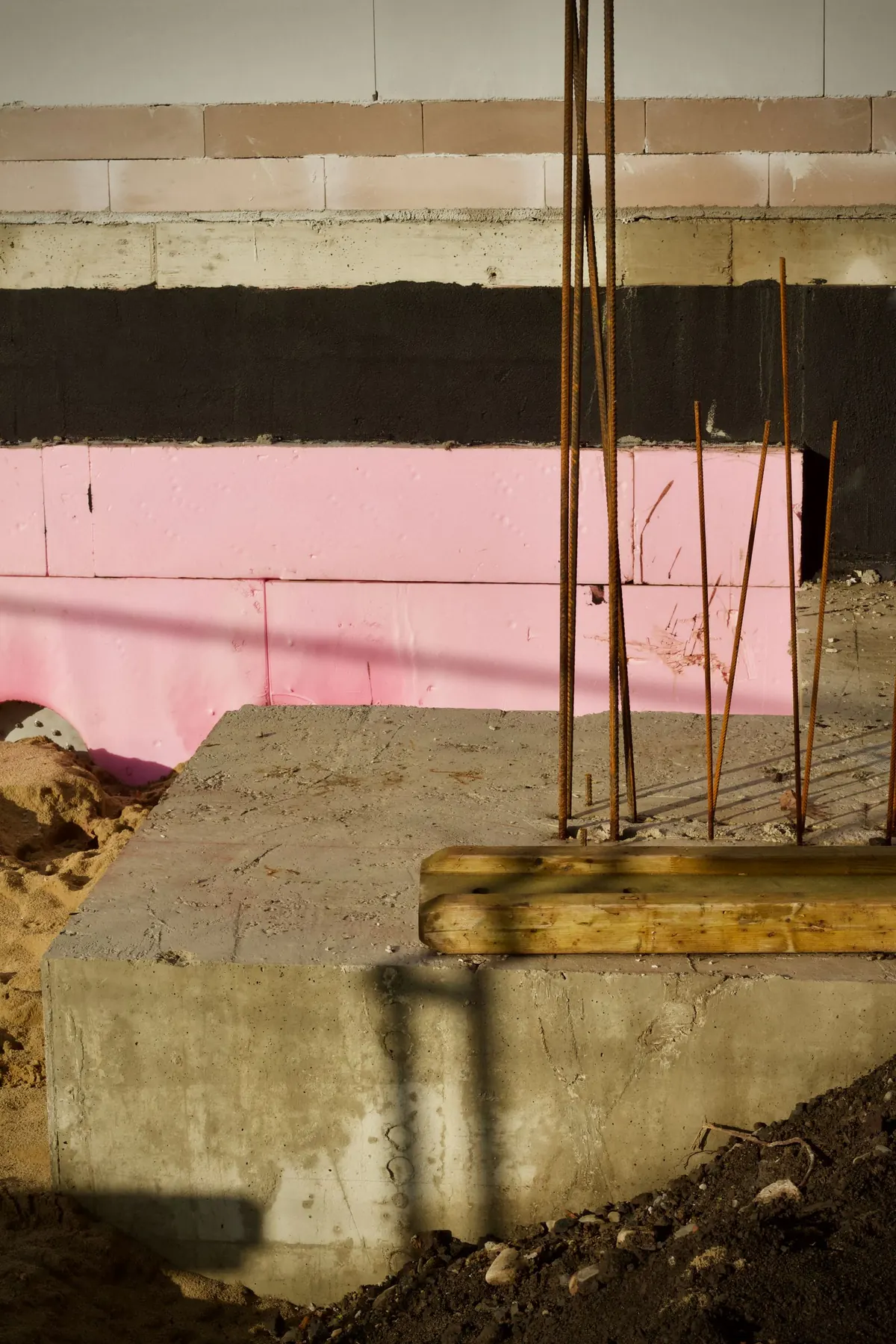 Concrete foundation with rebar dowels and rigid foam insulation at a construction site
