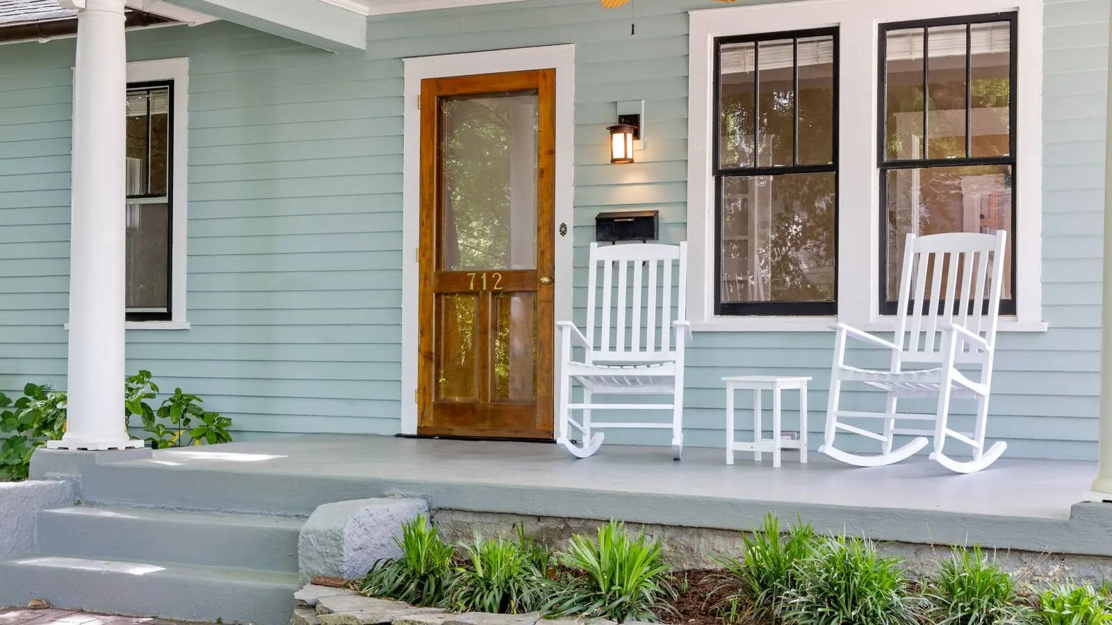 Front porch entry with painted concrete steps and a walkway leading to the door