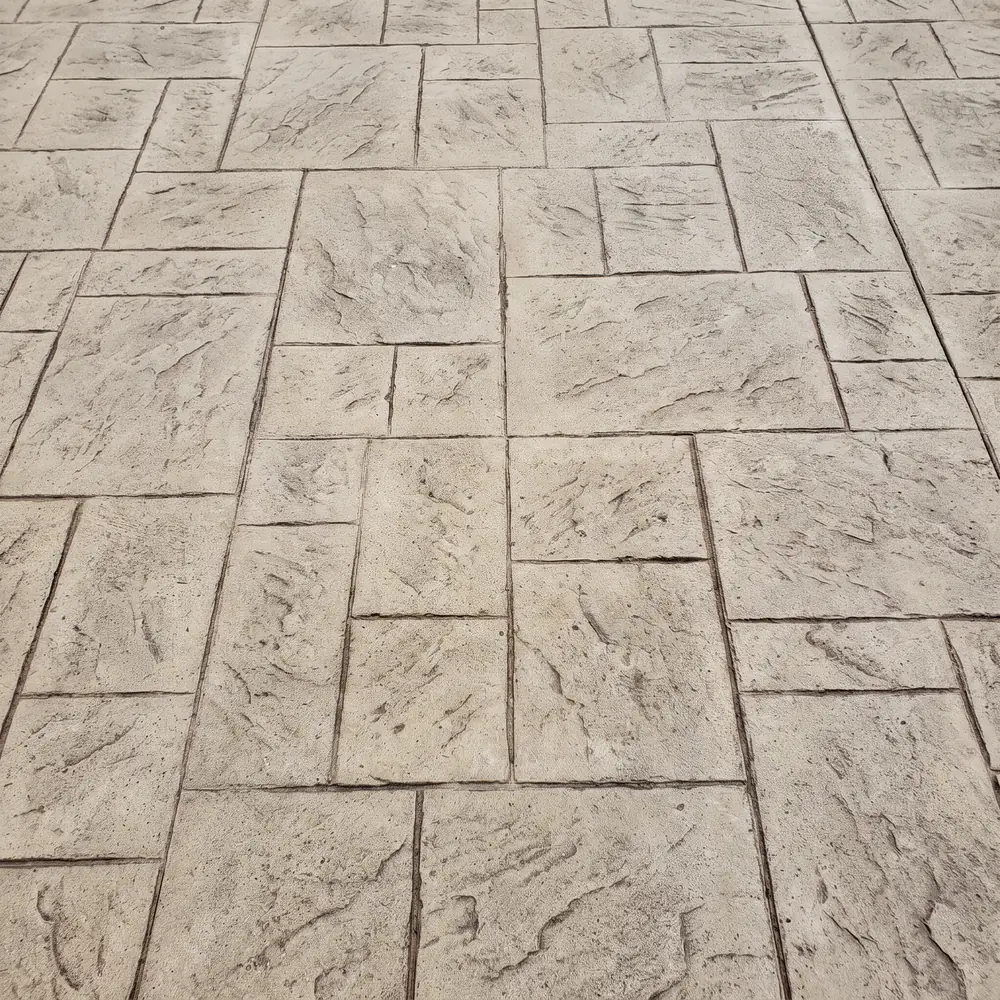 Ashlar slate stamp pattern pressed into a concrete slab in buff tones