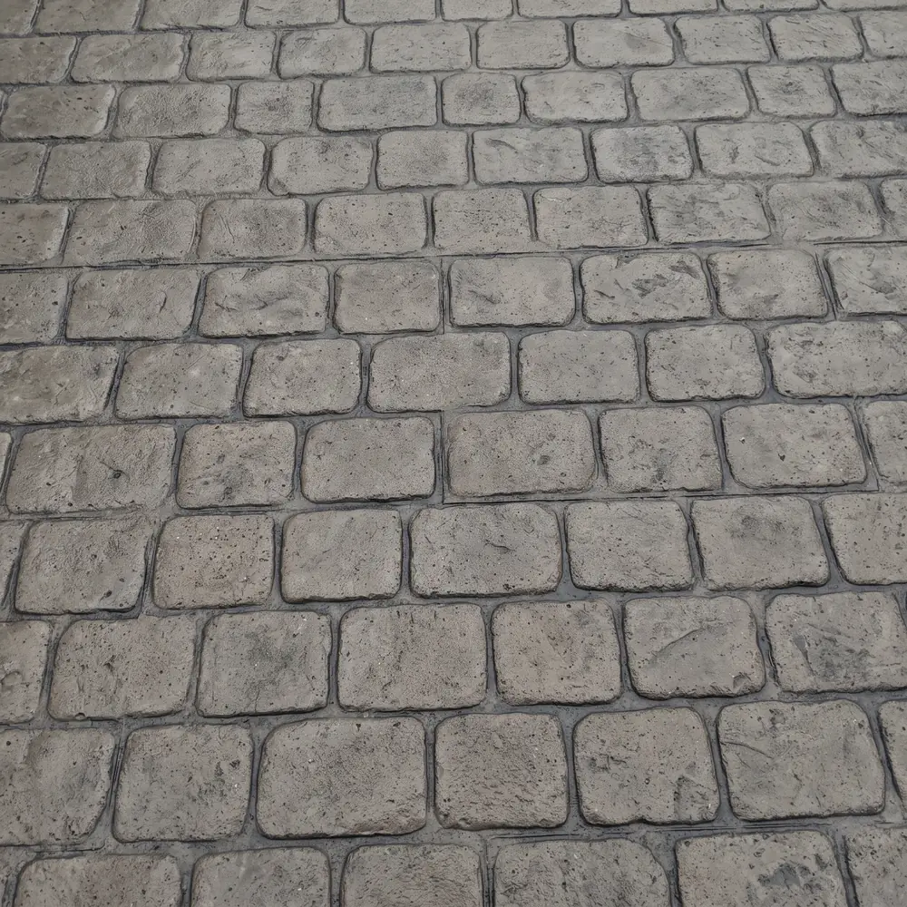 Cobblestone stamp pattern pressed into a concrete slab in warm gray