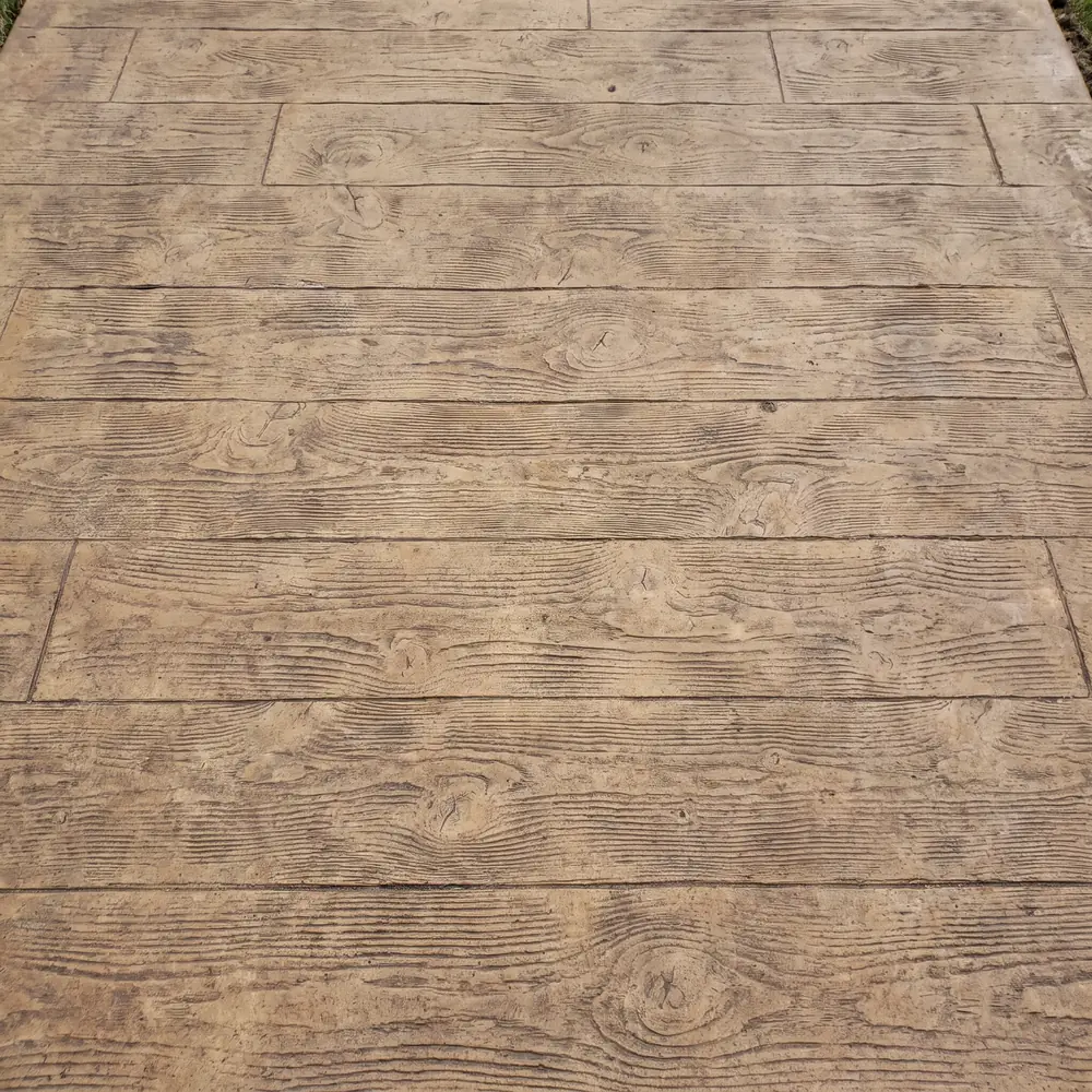 Wood plank stamp pattern with grain and knots pressed into a concrete slab