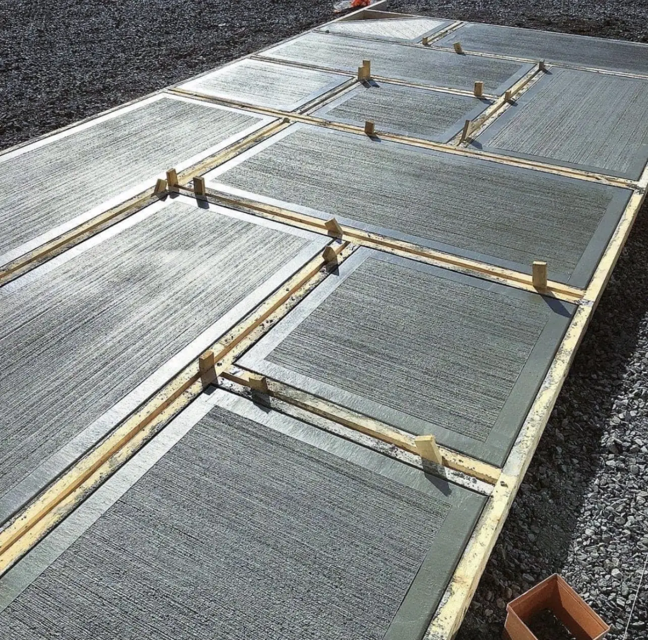 Freshly poured driveway panels with smooth troweled borders, forms still in place