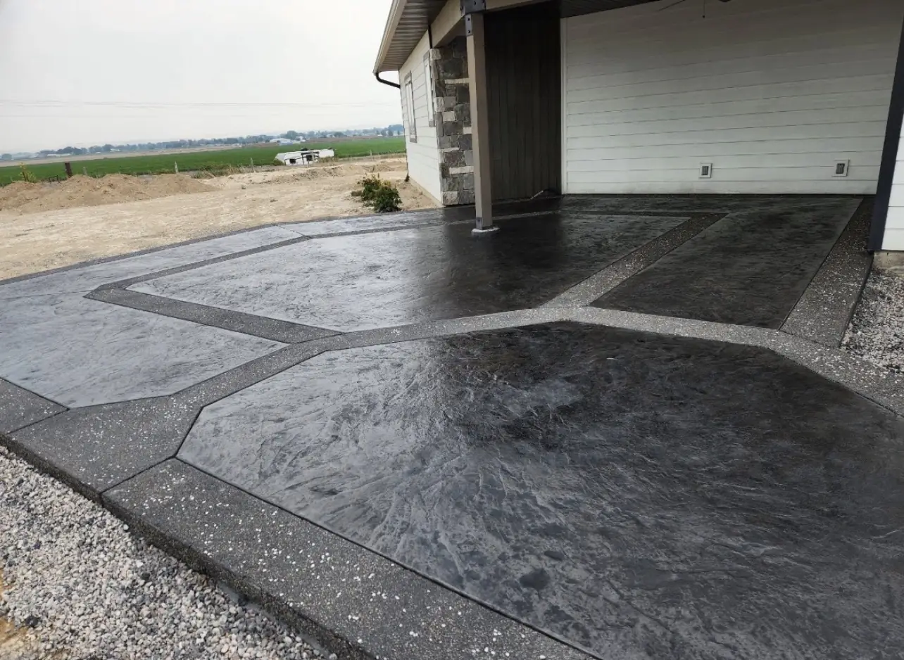 Slate textured stamped concrete patio in charcoal with exposed aggregate border